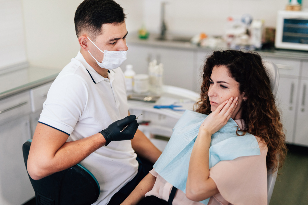 Woman holding her mouth beside dentist