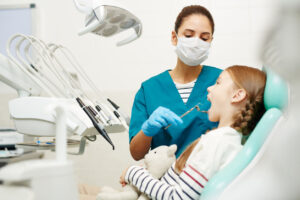 Image of Pediatric dentistry where a girl child is with a dentist and receiving pediatric dental care.